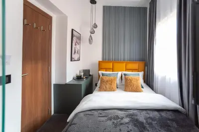 a bedroom with a large bed with a wooden headboard at Pedestrian street Center of Belgrade - mini rooms with paid PARKING in Belgrade