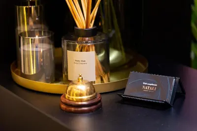 a table with a bottle and a book and candles at Pedestrian street Center of Belgrade - mini rooms with paid PARKING in Belgrade