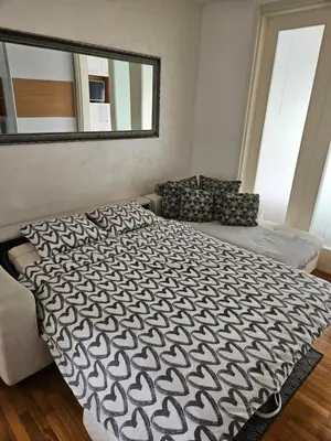 a bedroom with a large bed and a mirror at Belville Delta City apartment, free parking in Belgrade