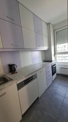 a kitchen with white cabinets and a counter top at Belville Delta City apartment, free parking in Belgrade