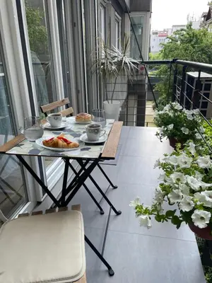 a table with a plate of food on a balcony at Alma Vracar in Belgrade