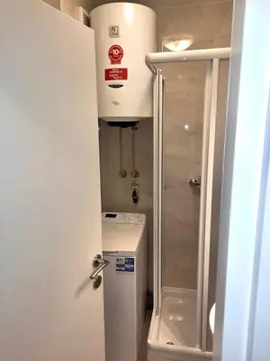 a small bathroom with a refrigerator and a shower at Alma Vracar in Belgrade