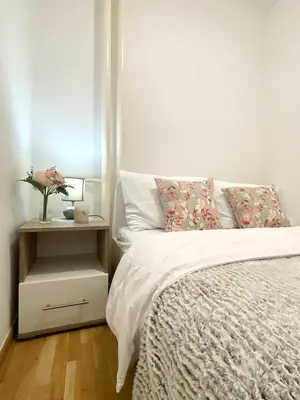 a bedroom with a white bed and a nightstand with a bed sidx sidx sidx at Alma Vracar in Belgrade