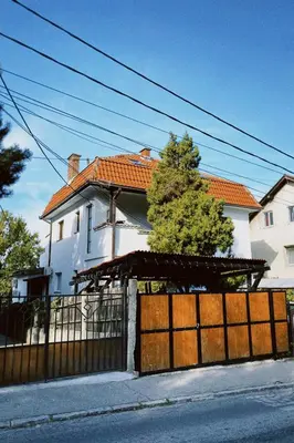 a white house with a gate and a fence at Apartment Smokva in Belgrade