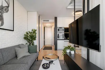 a living room with a gray couch and a flat screen tv at Deer Lux apartment Novi Dorcol-free parking in Belgrade