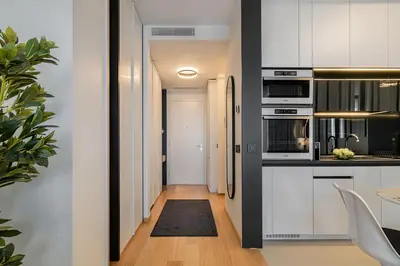 a kitchen with white cabinets and a black and white appliances at Deer Lux apartment Novi Dorcol-free parking in Belgrade