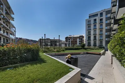 a dog is sitting on a bench in a courtyard at Deer Lux apartment Novi Dorcol-free parking in Belgrade
