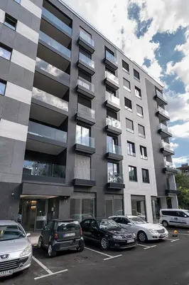 a parking lot with cars parked in front of a building at Deer Lux apartment Novi Dorcol-free parking in Belgrade