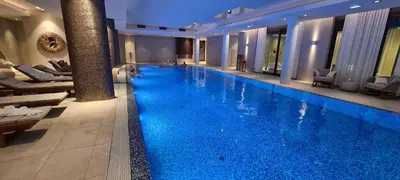 a large swimming pool with blue water in a building at Deer Lux apartment Novi Dorcol-free parking in Belgrade