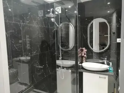 a black bathroom with two sinks and mirrors at Anejo Belvil in Novi Beograd