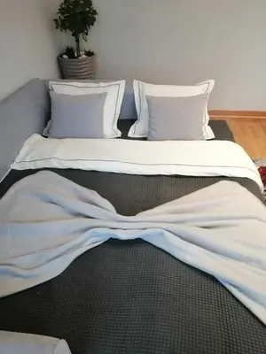 a large bed with white sheets and pillows at Anejo Belvil in Novi Beograd