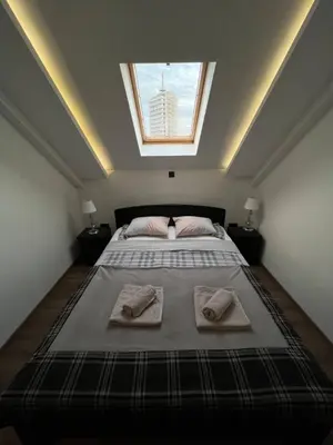a bedroom with a large bed with two towels on it at MAIN SQUARE Apartment in Belgrade