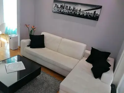 a living room with a white couch and a coffee table at Apartment Belville, Suncokret 34 in Novi Beograd