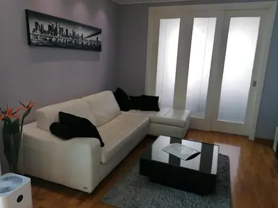 a living room with a white couch and a coffee table at Apartment Belville, Suncokret 34 in Novi Beograd