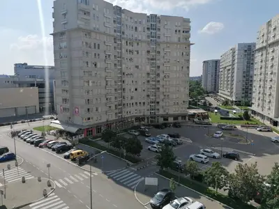 a large apartment building in a parking lot with cars at Apartment Belville, Suncokret 34 in Novi Beograd