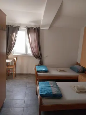 a dorm room with three beds and a window at LIBERO APARTMANI in Surčin