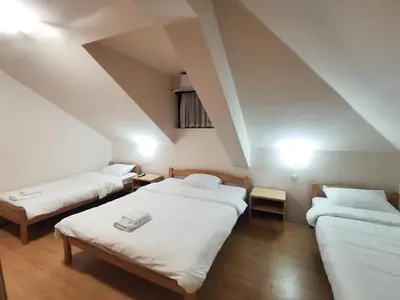 a room with three beds in a attic at Motel Imperija in Ub