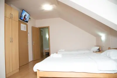 a bedroom with a white bed in a attic at Motel Imperija in Ub