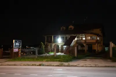 a house with a light on the side of it at night at Motel Imperija in Ub