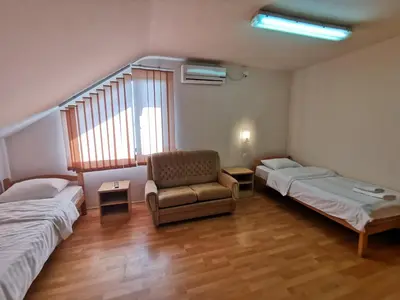 a room with two beds and a chair and a window at Motel Imperija in Ub