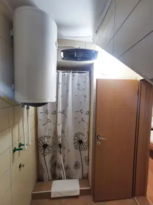 a bathroom with a shower curtain and a door at Motel Imperija in Ub