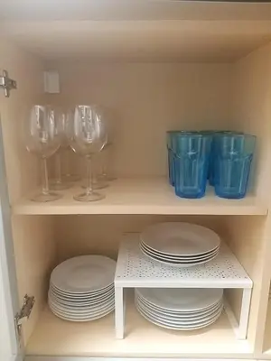 a cupboard filled with plates and wine glasses at CITY CENTER Apartment in Belgrade
