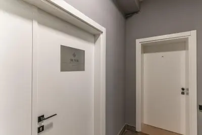 a hallway with a white door and a mirror at Silver Luxury Suites in Belgrade
