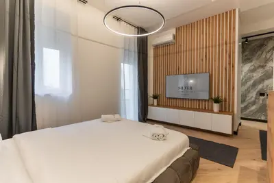a bedroom with a large white bed and a flat screen tv at Silver Luxury Suites in Belgrade