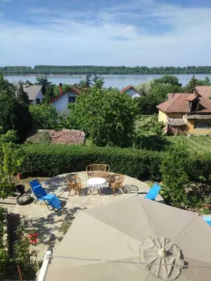 a patio with a table and chairs and an umbrella at Lux Apartmans-VILA MALI RAJ in Udovice