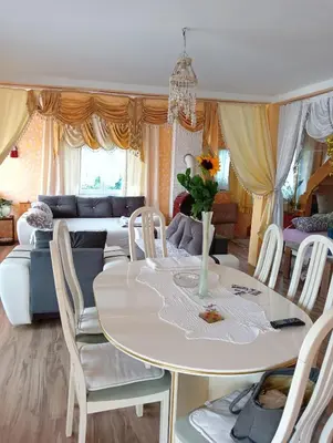 a living room with a table and chairs and a couch at Lux Apartmans-VILA MALI RAJ in Udovice
