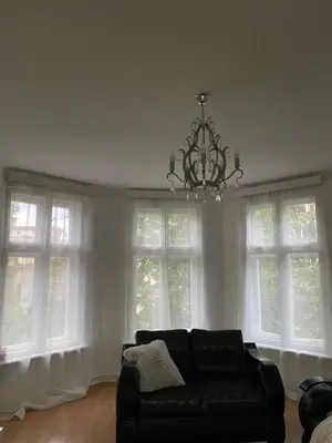 a living room with a black couch and windows at Belgrade centrum in Karaburma