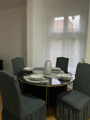 a dining room table with chairs and a table with plates at Belgrade centrum in Karaburma