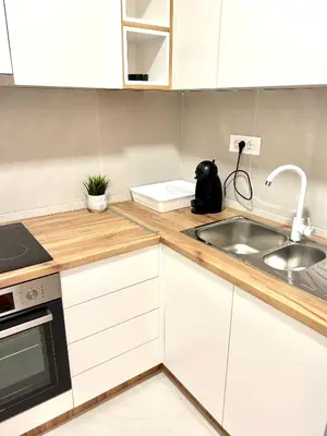 a kitchen with white cabinets and a sink at Bulevard Luxury Suites in Belgrade