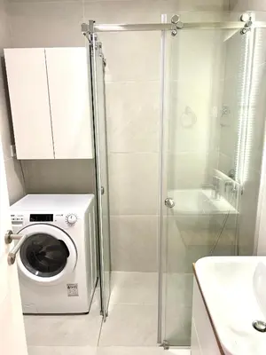 a washing machine in a bathroom with a shower at Bulevard Luxury Suites in Belgrade