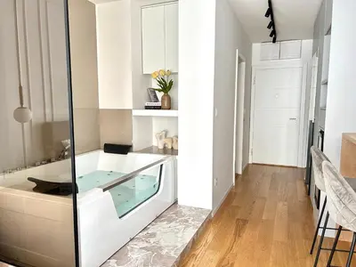 a white kitchen with a glass box in the middle at Bulevard Luxury Suites in Belgrade