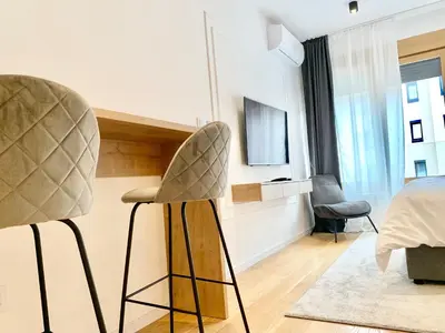 a bedroom with a chair and a bed and a television at Bulevard Luxury Suites in Belgrade