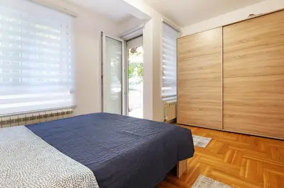 a bedroom with a blue bed and wooden cabinets at Lion Apartment - Belgrade in Belgrade