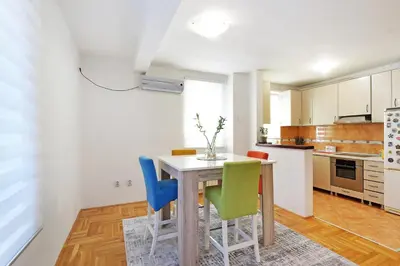 a kitchen with a wooden table and chairs at Lion Apartment - Belgrade in Belgrade