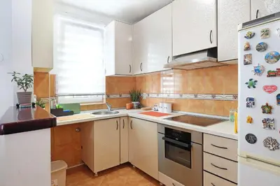 a kitchen with white cabinets and a white refrigerator at Lion Apartment - Belgrade in Belgrade
