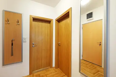 a hallway with two wooden doors and a mirror at Lion Apartment - Belgrade in Belgrade