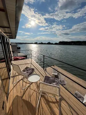 a boat deck with chairs and a table on the water at Splav Shoom in Ostružnica