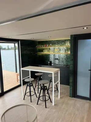 a kitchen with a table and stools in a room at Splav Shoom in Ostružnica
