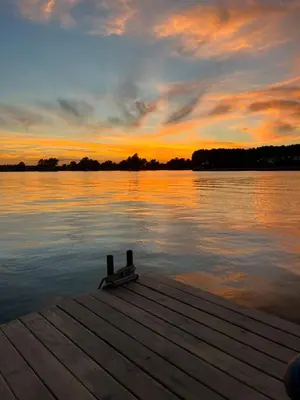 a sunset over a dock on a body of water at Splav Shoom in Ostružnica