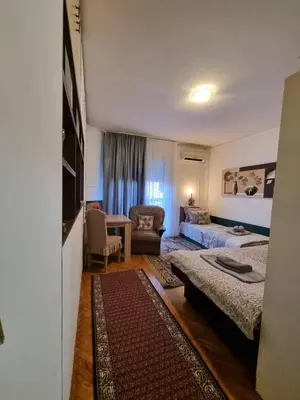 a bedroom with two beds and a living room at Apartment Dorcol Belgrade in Belgrade