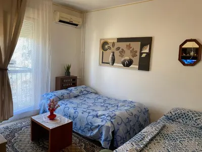 a bedroom with a bed and a table and a window at Apartment Dorcol Belgrade in Belgrade