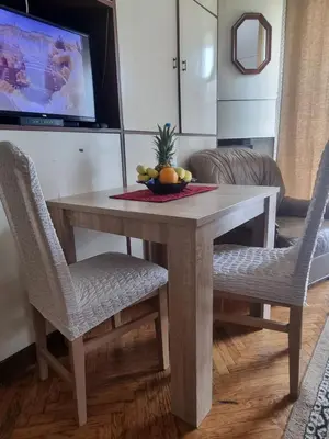 a dining room table with two chairs and a television at Apartment Dorcol Belgrade in Belgrade