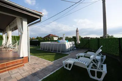 a patio with a table and chairs on a lawn at Green Art House in Kovilovo