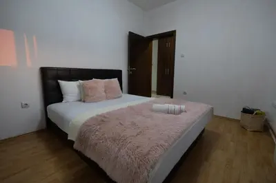 a bedroom with a large bed with a pink blanket at Green Art House in Kovilovo