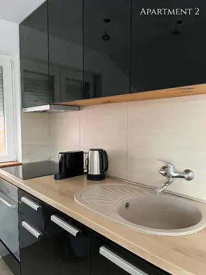 a kitchen counter with a sink with two toasters at Airport Gate 25 in Ledine
