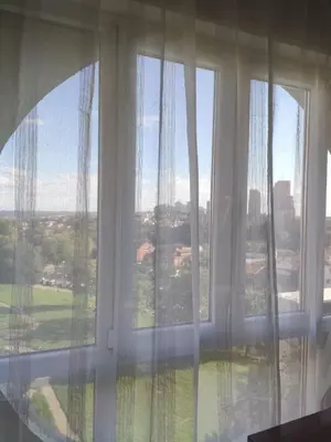 a window with white curtains and a view at Venac in Belgrade